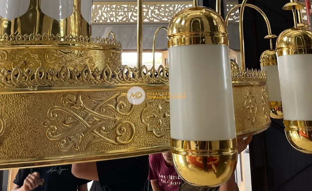 10 Inspirasi Lampu Gantung Ruang Tamu Custom: Material Tembaga Kuningan Langsung Pengrajin 9 Lampu gantung kuningan model Nabawi anti karat, desain klasik dengan ukiran kaligrafi dan motif Islami detail, kaca dekoratif berkualitas, memancarkan cahaya lembut, menghadirkan kesan elegan, megah, dan awet untuk masjid, mushola, atau ruang tamu.