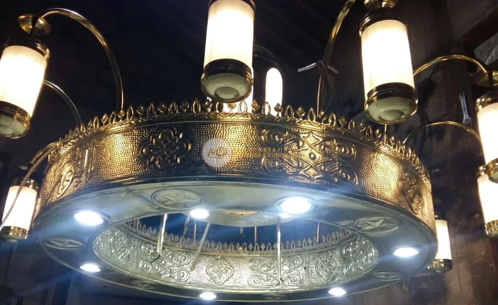 10 Inspirasi Lampu Gantung Ruang Tamu Custom: Material Tembaga Kuningan Langsung Pengrajin 4 Lampu gantung Nabawi dari kuningan dengan ukiran klasik Madinah, desain artistik dengan motif Islami dan kaca dekoratif, pencahayaan hangat, menciptakan suasana mewah, sakral, dan berkelas untuk masjid, mushola, atau ruang tamu elegan.