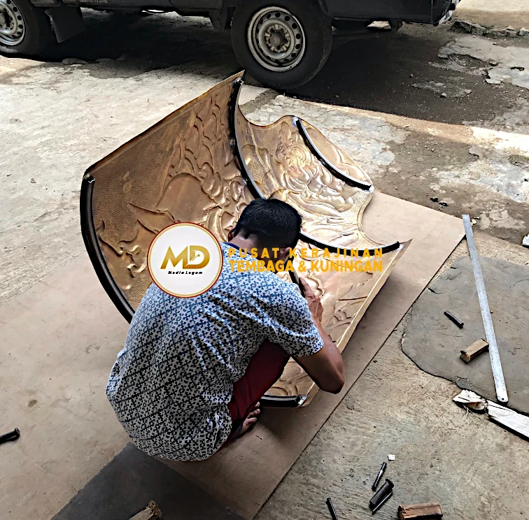Proses Pembuatan hingga Pemasangan Hiasan Tiang Kuningan: Ornamen Barong Bali 9 ketok manual pada ornamen barong kuningan membantu menonjolkan detail ukiran sehingga terlihat lebih tajam dan berkarakter