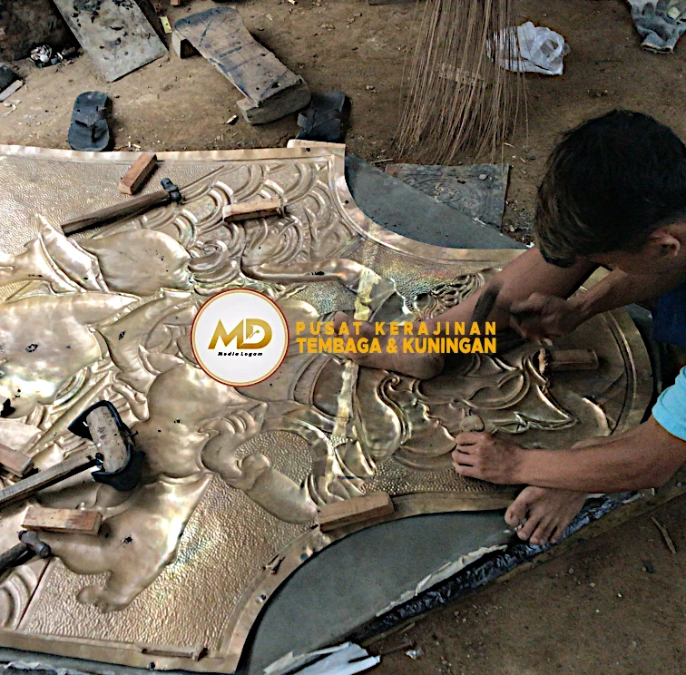 Proses Pembuatan hingga Pemasangan Hiasan Tiang Kuningan: Ornamen Barong Bali 13 proses ketok hiasan barong kuningan dilakukan dengan ritme pukulan terkontrol untuk membentuk relief yang dalam dan konsisten, menghasilkan detail ukiran yang rapi, presisi, serta memperkuat karakter artistik pada setiap bagian ornamen